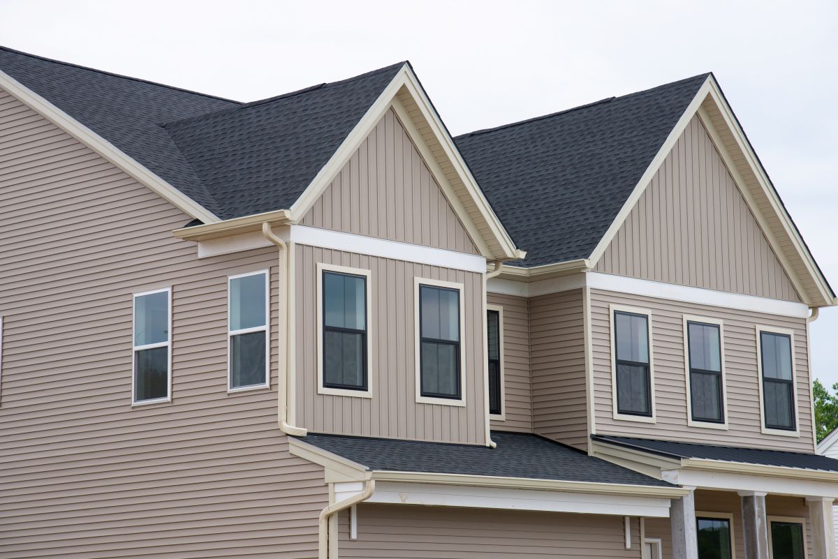big house with shingles roof beige siding