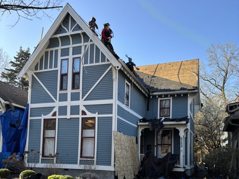 workers repairing shingles roof