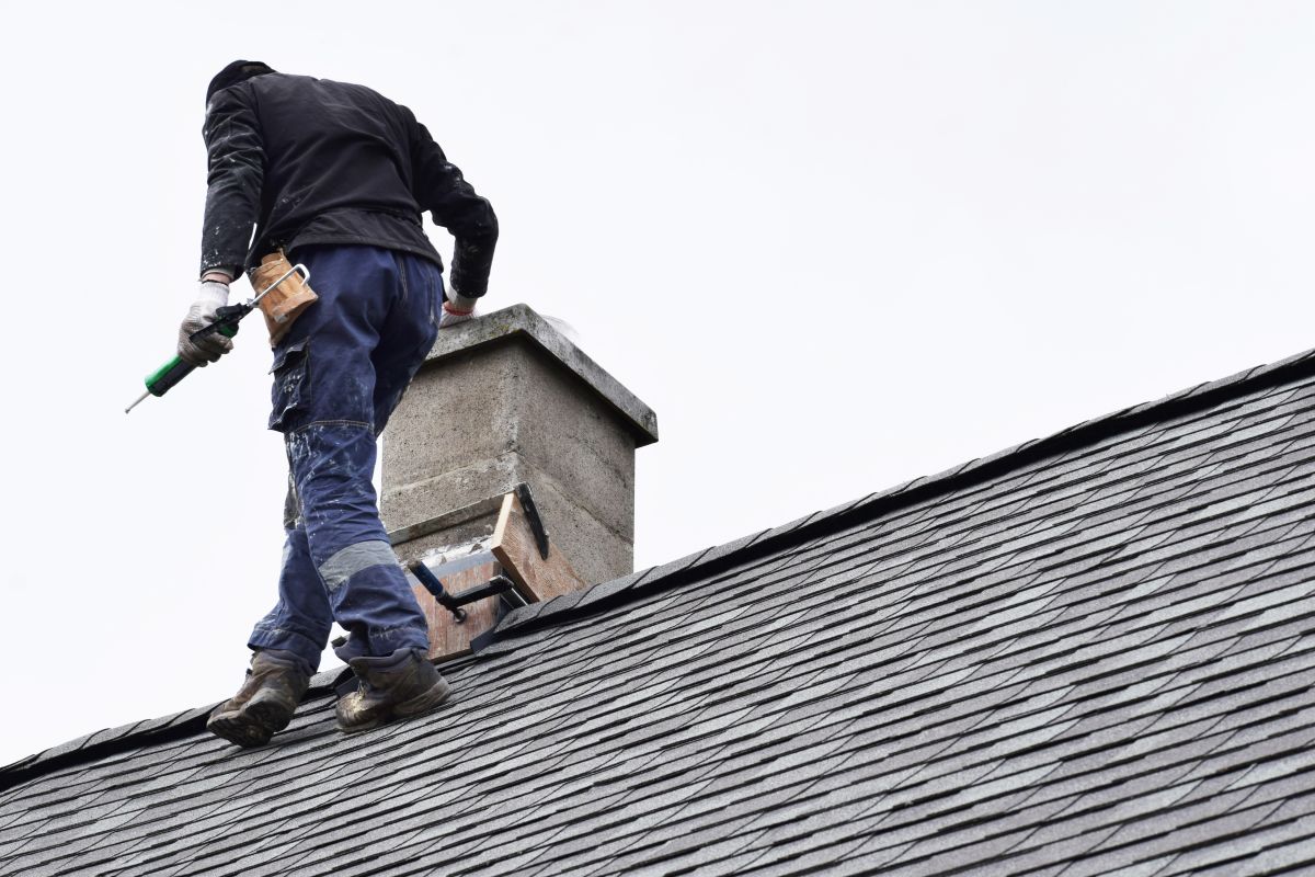 guy fixing roof with sealant